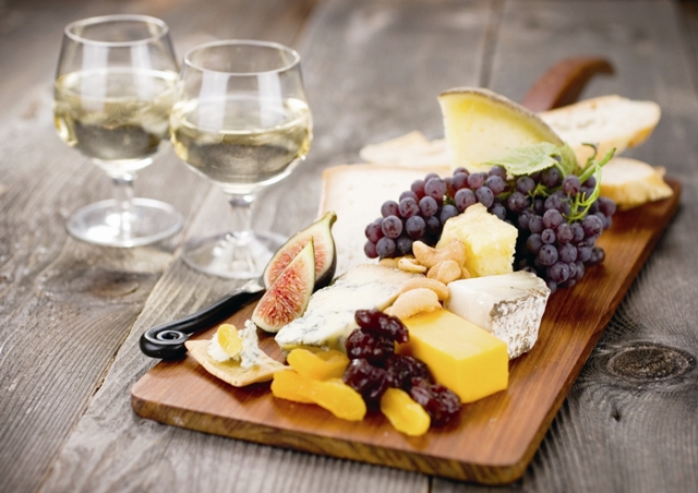 A delectable cheeseboard filled with an assortment of fine imported cheeses and served with dessert wine.  Shallow dof.